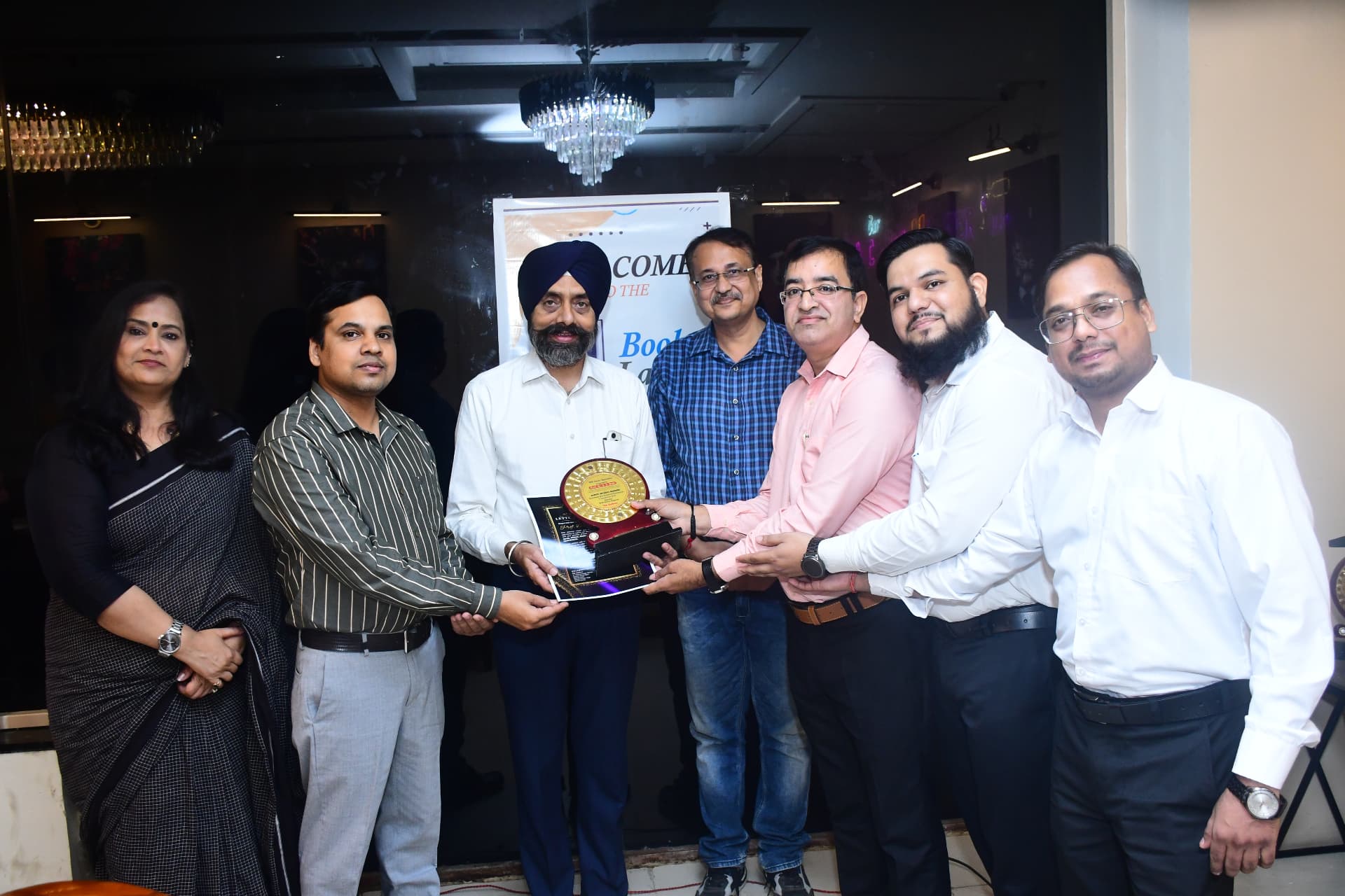 Dignitaries felicitating the authors of Agents Without Borders with a plaque of appreciation